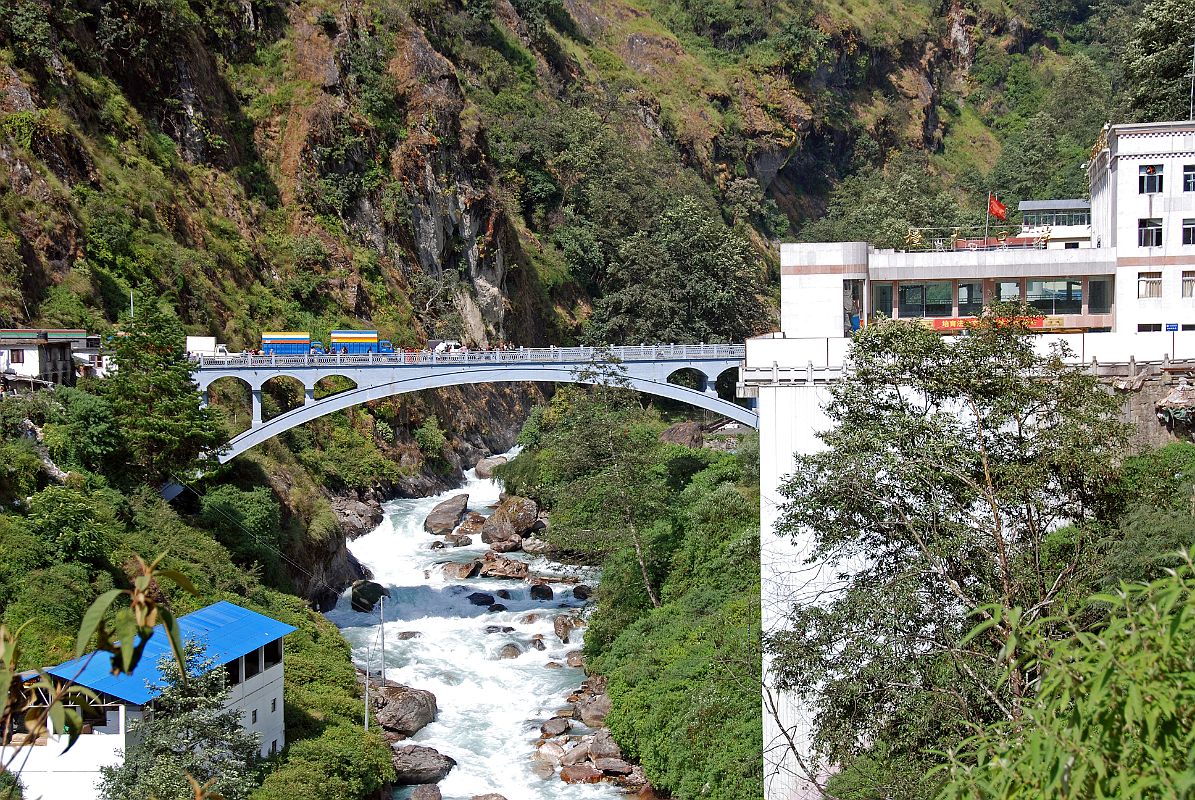 09 Friendship Bridge Between Kodari Nepal And Zhangmu Tibet After Crossing The Friendship Bridge From Kodari After passing through China Customs and Immigration, I walk up the road to our awaiting Landcruiser. I look back to see the thundering Bhote Kosi (River From Tibet) flowing under the Friendship Bridge.